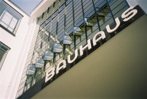 Bauhausi asutaja rõhutas vajadust arendada välja disainidistsipliin, mis hõlmaks skaalat pisimast suurimani, võttes omaks „totaalse arhitektuuri“ põhimõtted, selle uue orgaanilise arhitektuuri, mis on üheaegselt tööstusajastu toodanguks ja väljenduseks.  Fotol Herbert Bayeri loodud kirjatüüp Bauhausi kooli fassaadil Dassaus.  
