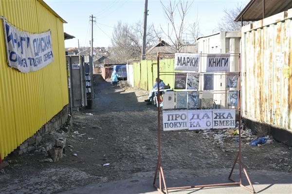 1990ndad on mõnes mõttes Ukraina provintsilinnades tagasi – müüakse kõike mida võimalik ja mida keegi ainult osta soovib. Fotol müüb-ostab-vahetab mees garaažide vahel raamatuid ja marke.